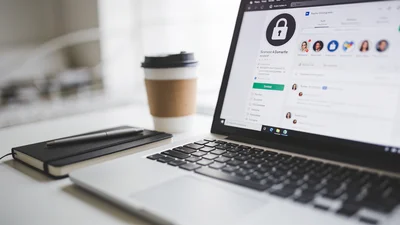 Notebook s otvorenou sociálnou sieťou a zámkom na pracovnom stole