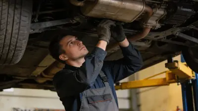 Auto na zdviháku v autoservise, mechanik pracuje