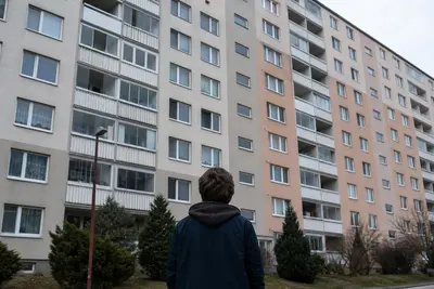 Mladý pár stojaci pred bytovým domom