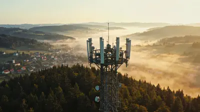 Telekomunikačný vysielač na kopci nad slovenskou dedinou v podvečernom svetle